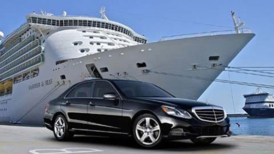A Mercedes Benz salon car parked in front of a cruise ship for chauffeur driven seaport transfers in Southampton & Portsmouth in the UK.